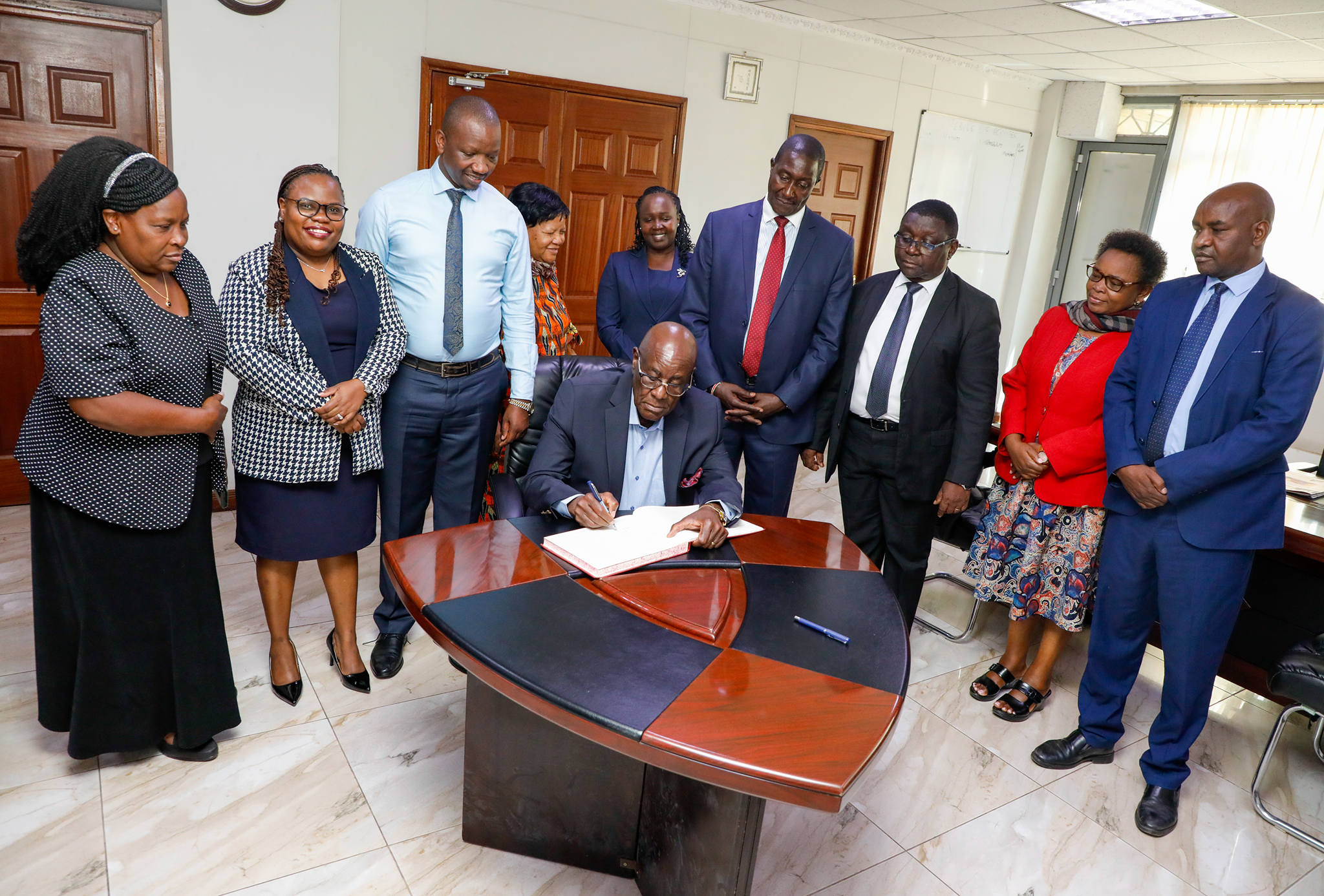 Hon. Justice Aggrey Muchelule signing the visitors book
